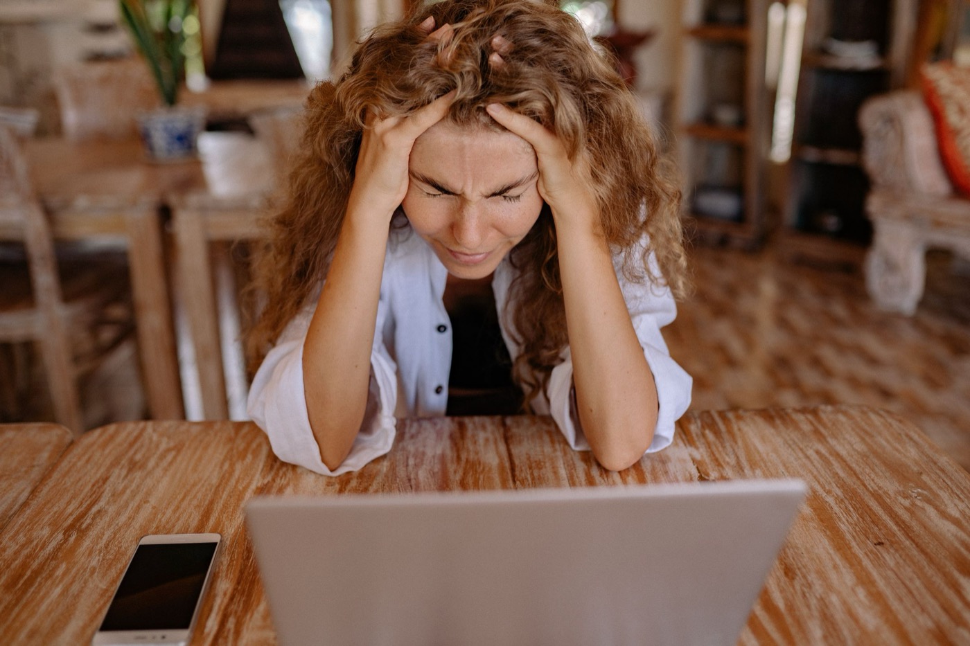 A job hunter with her hands in her hair, worn down by applications that go nowhere